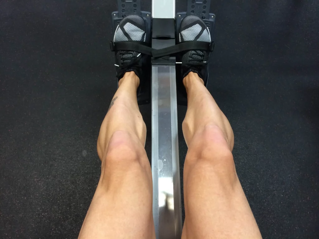someone's legs on a rowing machine