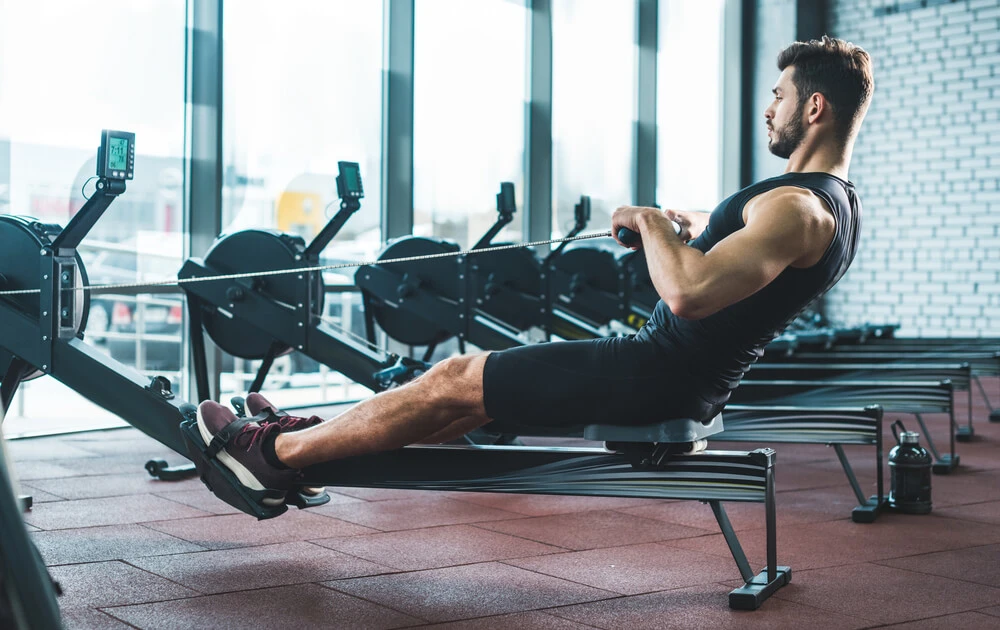 a man uses a rowing machine to compare before and after progression