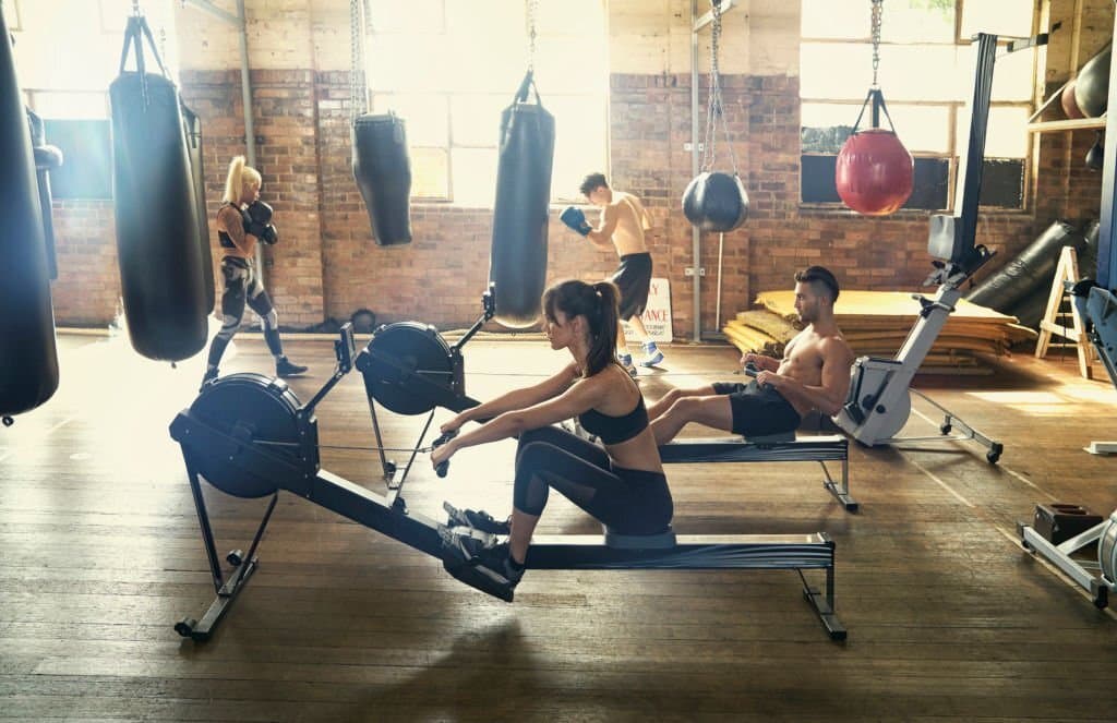 people working out with rowing machine