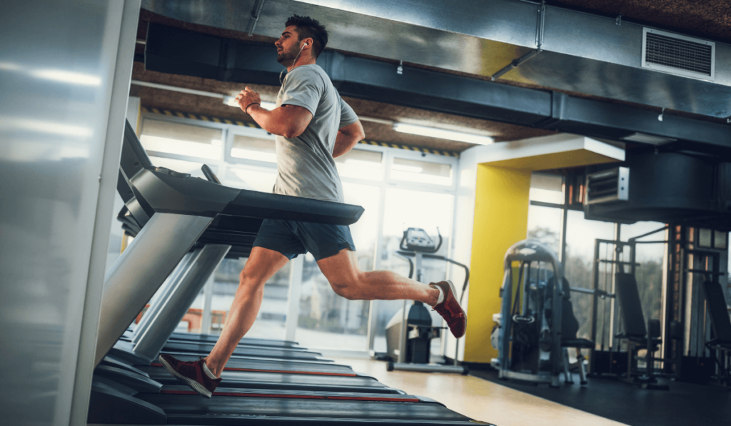 A man at a gym using a treadmill after discovering what are treadmills
