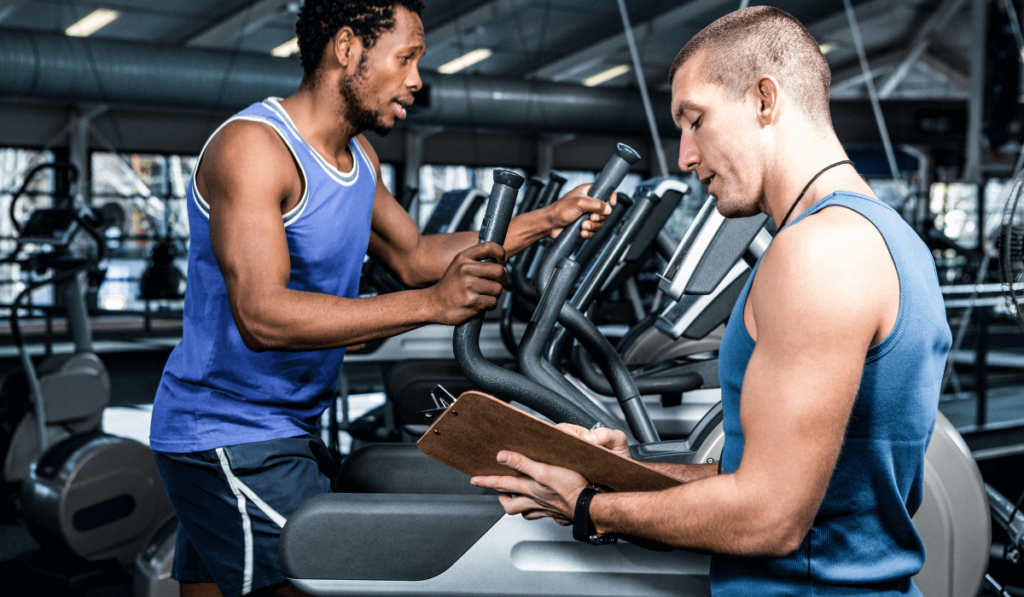 A man being coached to avoid knee pain on elliptical