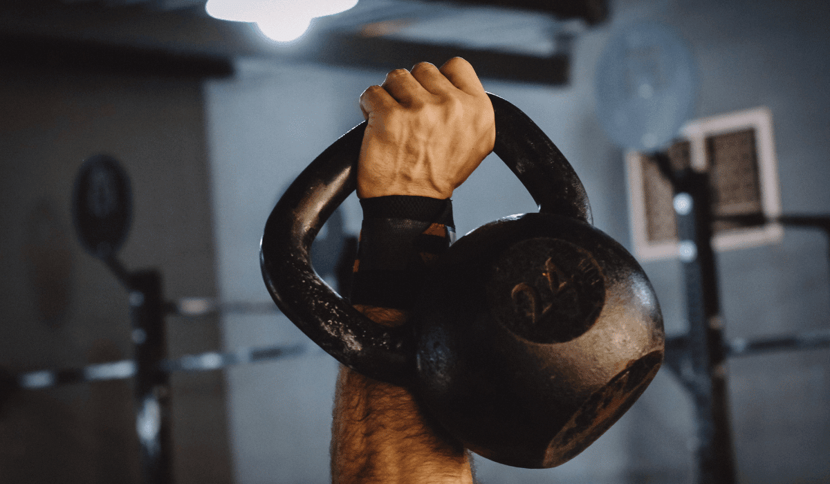 An athlete doing kettlebell workouts for men at the gym