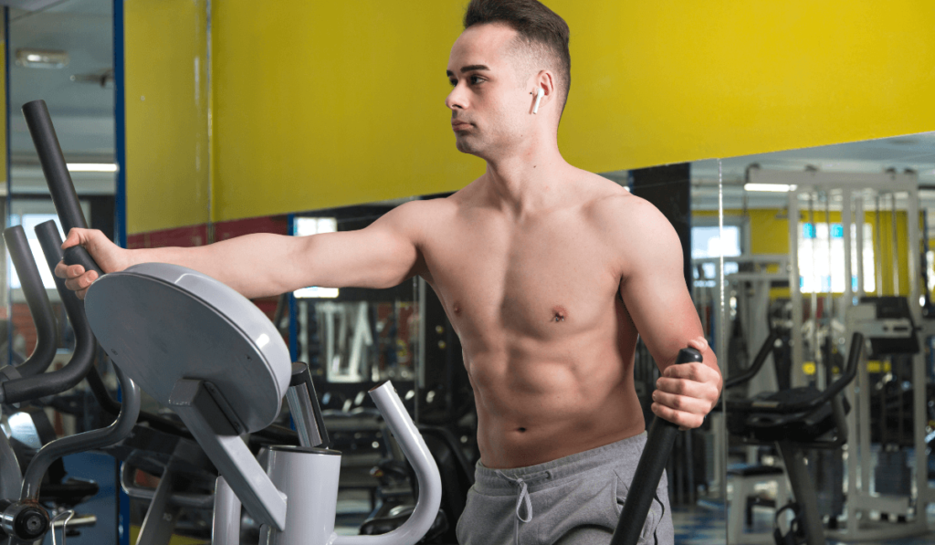 A muscular man knowing how long it takes on elliptical to see results