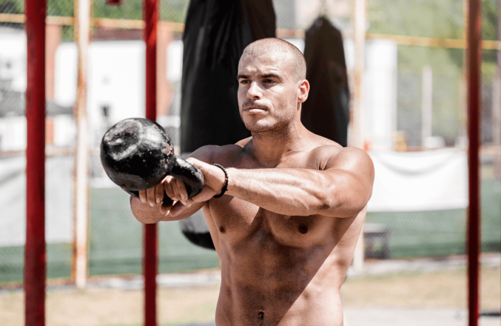 A man doing cardio kettlebell workout outside