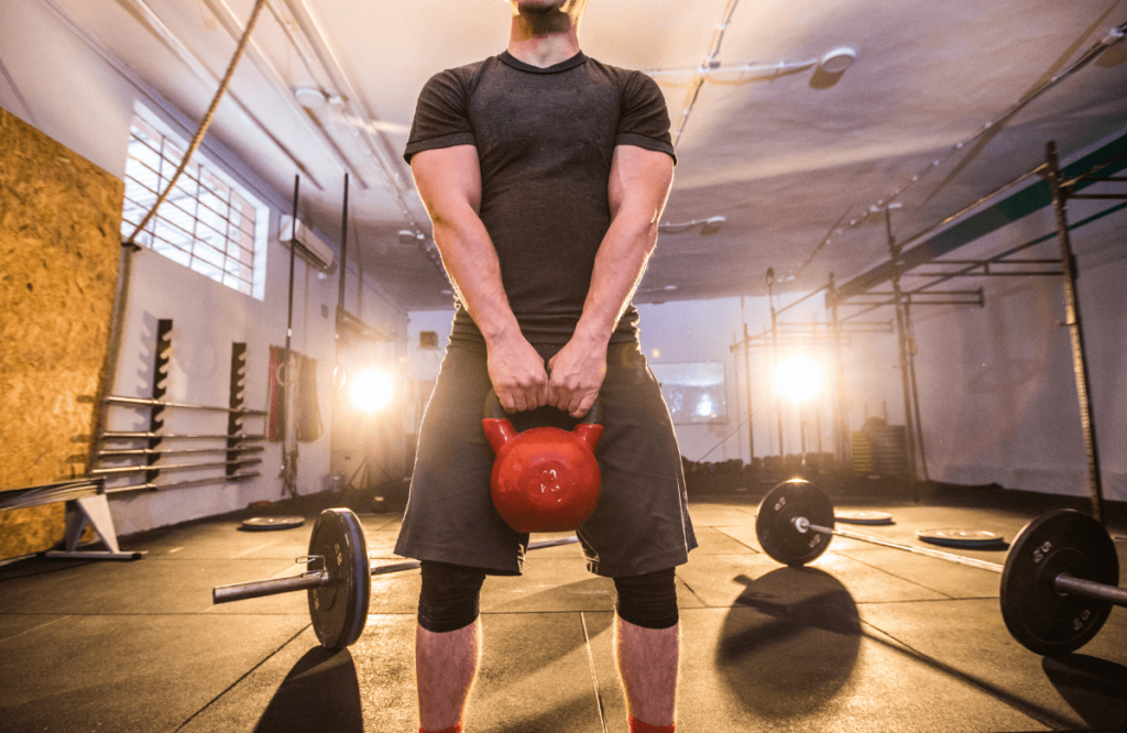 A man doing cardio kettlebell workout at the gym