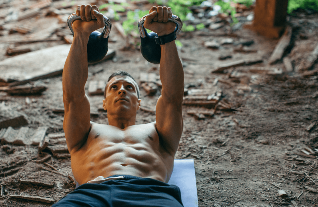 A man doing kettlebell chest workout outside