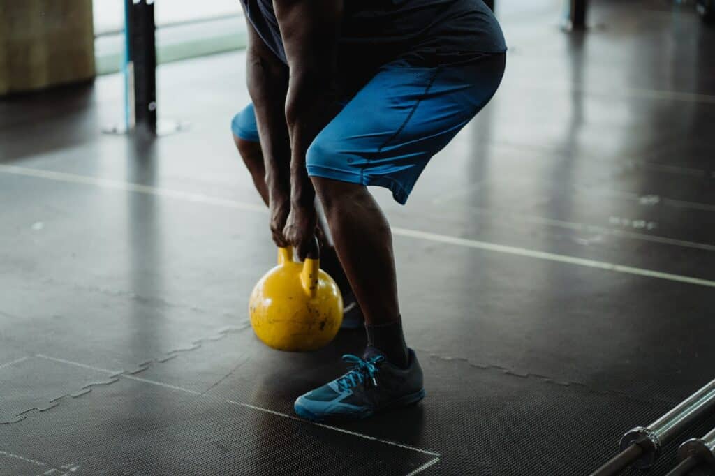 A man doing kettlebell deadlifts at the gym