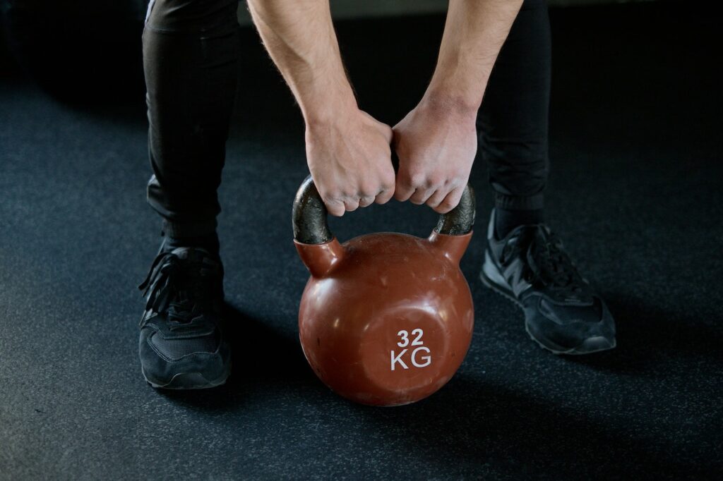 A man using a 32Kg kettlebell for his kettlebell deadlift training