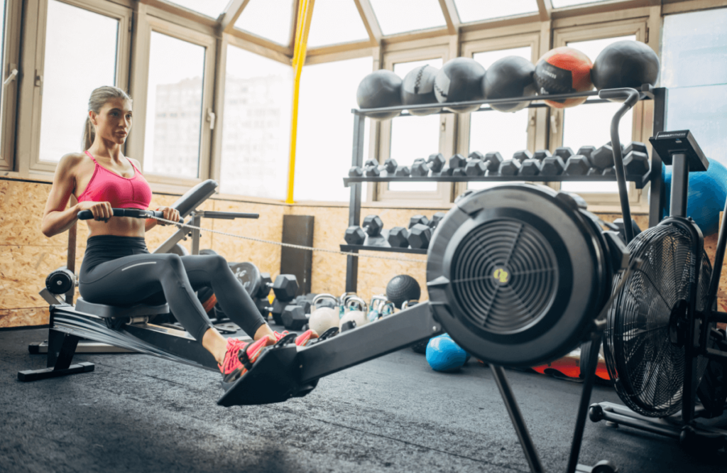 A woman in her home gym using a Fitness Reality Rowing Machine