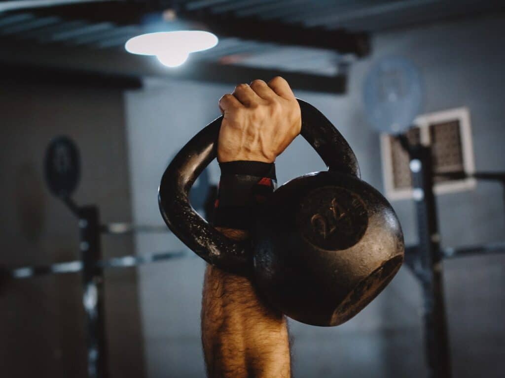 A kettlebell used by a man during a kettlebell thruster exercise