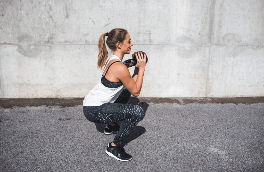 A woman experiencing knee pain when squatting