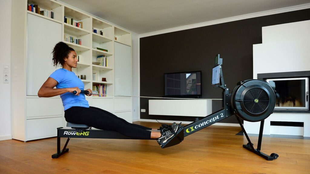 A woman using the rower after seeing the concept 2 model d reviews