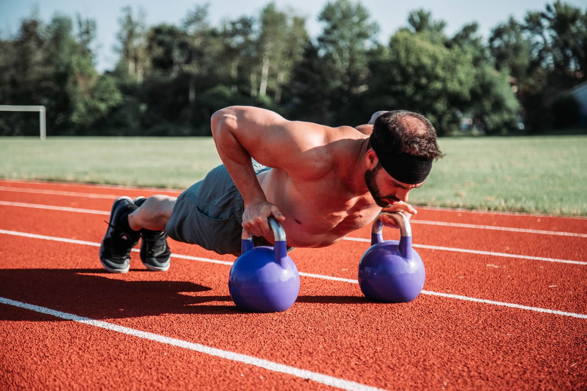 A man trying kettlebell challenges outside