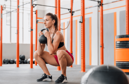 A woman at the gym doing goblet squats with a kettlebell