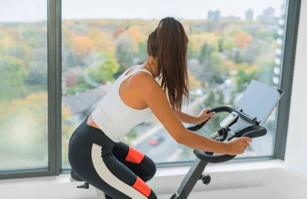 A woman at home doing an elliptical vs bike comparison