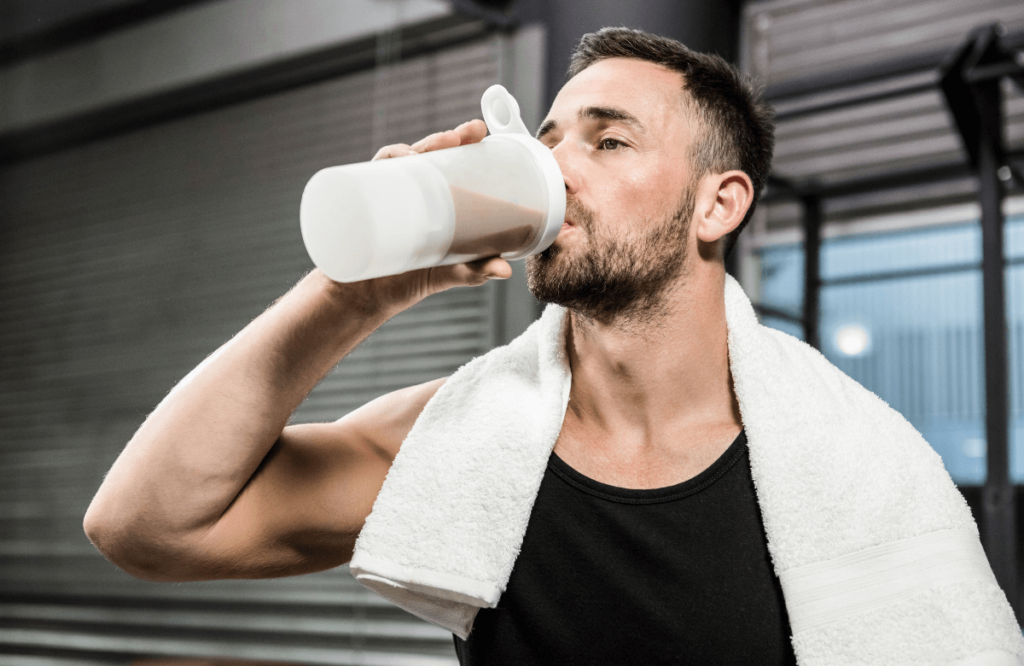 A skinny guy at the gym drinking protein shake to gain muscle easier