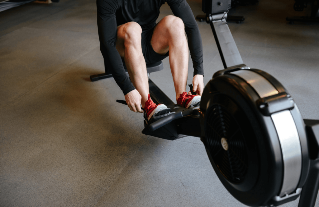A man preparing his workout by wearing the best shoes for rowing machine