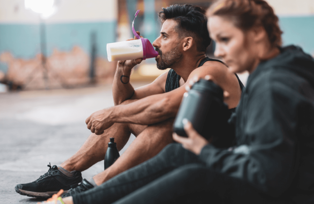 A couple at the gym with shakers knowing how much protein for weight loss is required