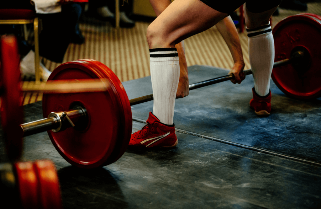 A man during a competition wearing the best deadlift slippers