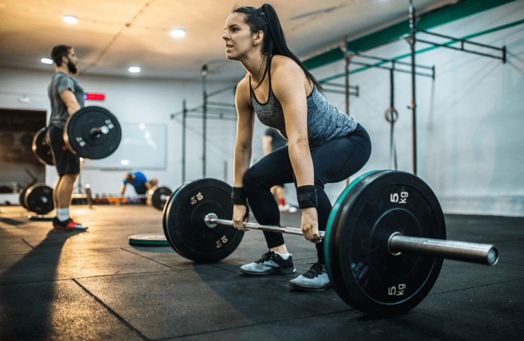A woman performing stiff leg deadlifts at the gym