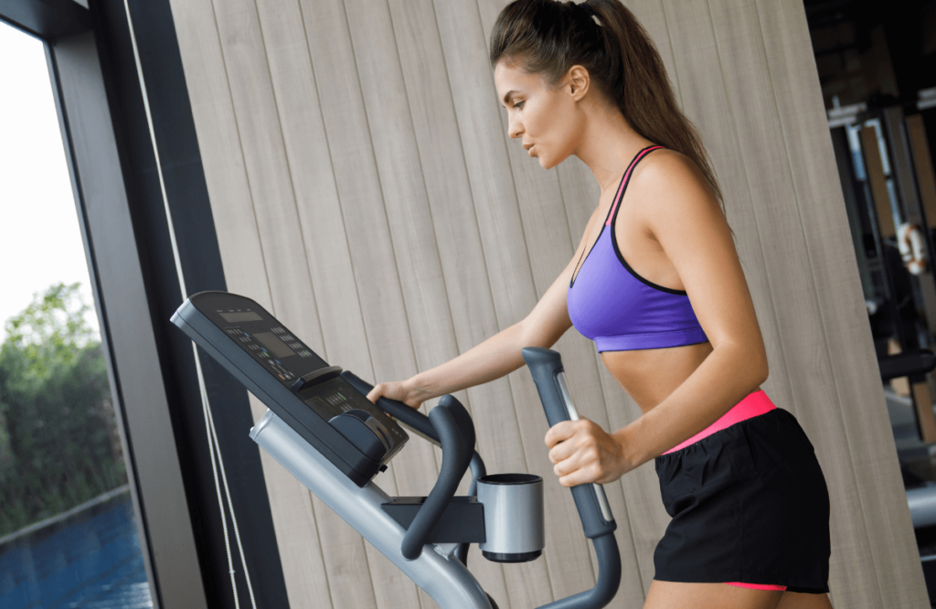 A woman training on an elliptical after reading Sole E25 elliptical reviews