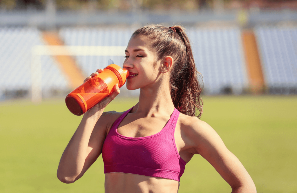 A woman outside drinking the best-stim free pre-workout
