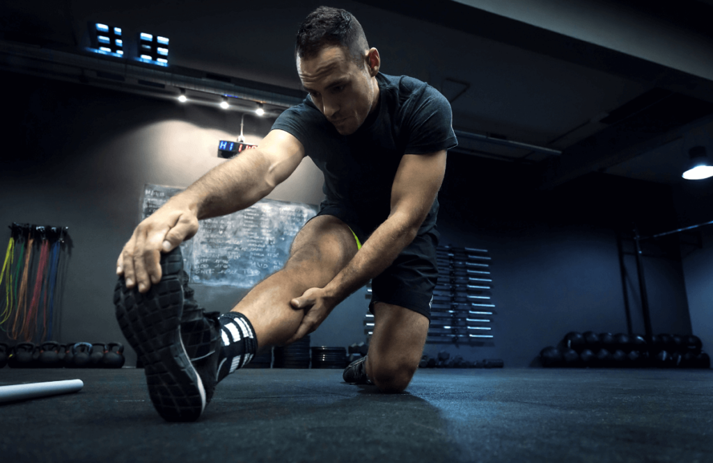 A man stretching at the gym to build muscles