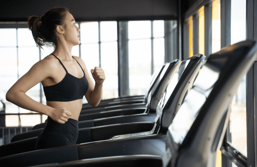 A woman running on a treadmill at the gym