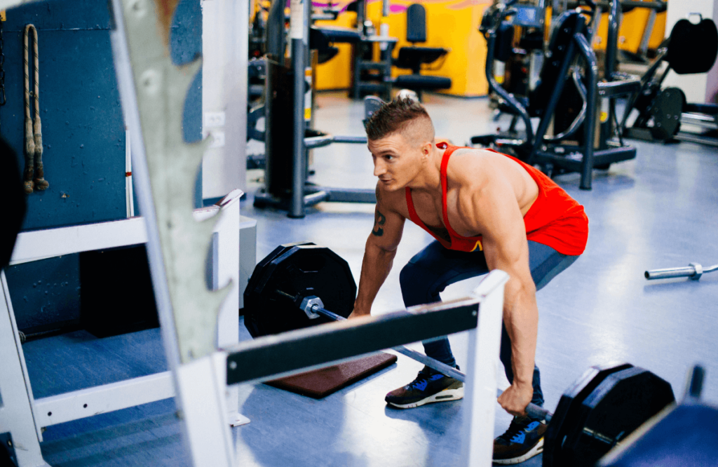 A man at the gym performing block pulls deadlifts