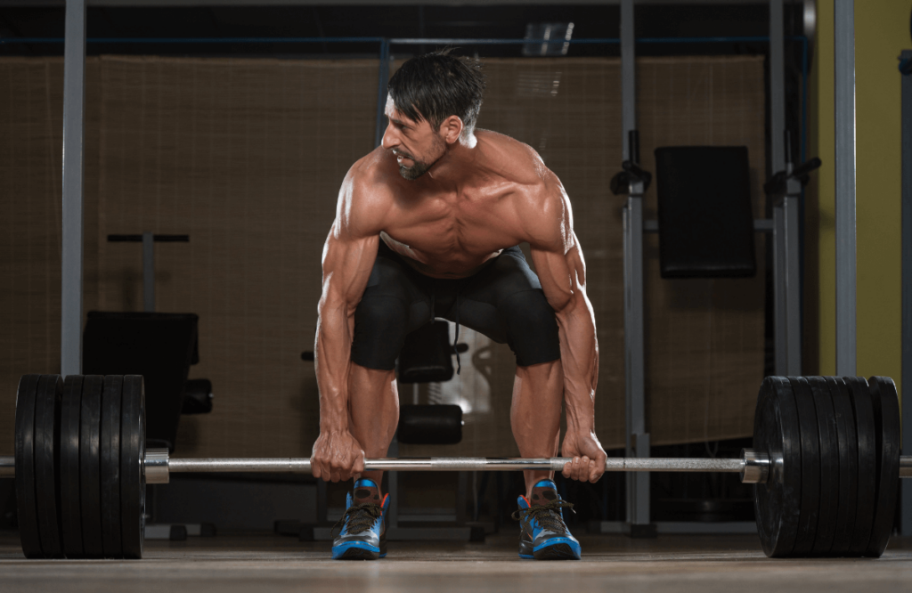 A muscular man doing deadlift properly to avoid lower back pain injury