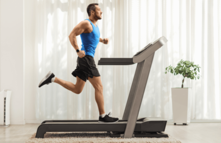 A man running on a treadmill after choosing which is the best between treadmill vs running outside