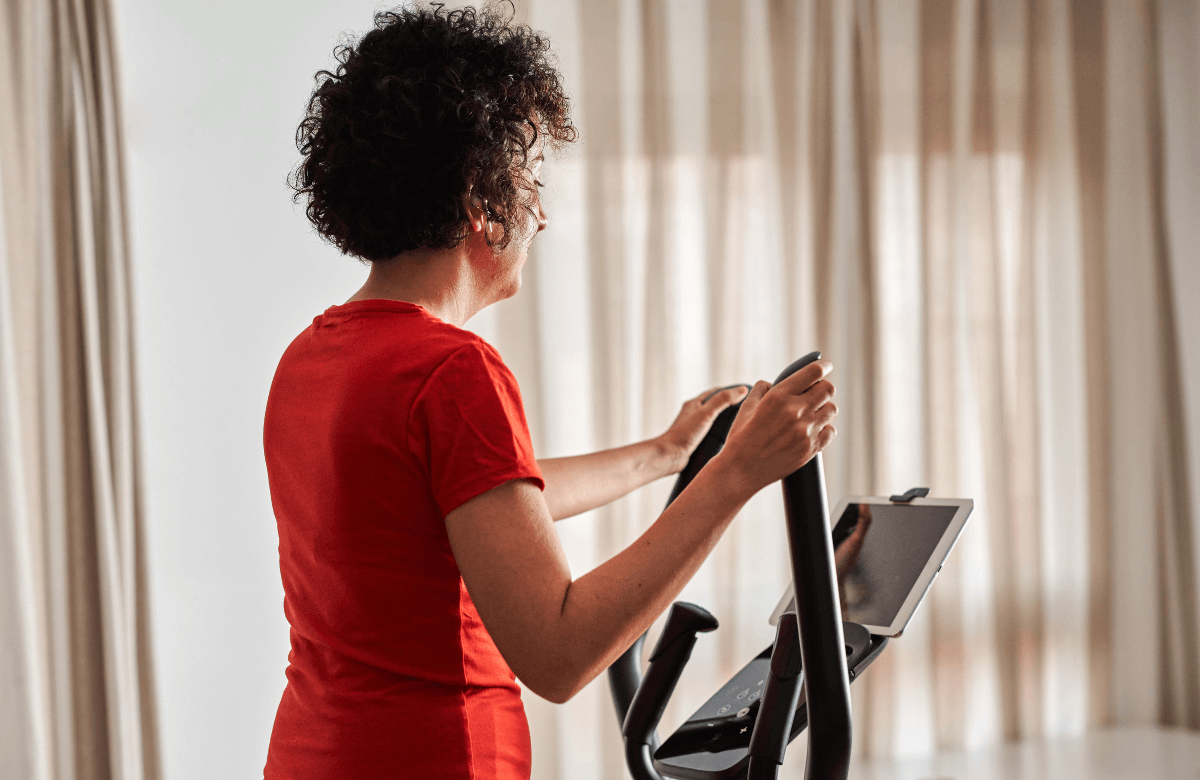 A woman using the best elliptical for apartment