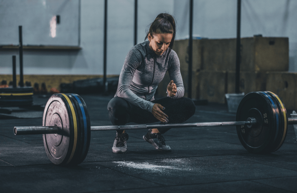 A woman performing deadlifts while pregnant at the gym