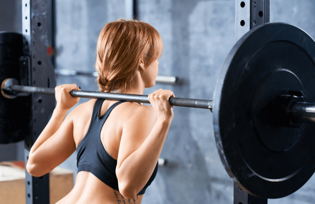 A woman performing deadlifts while pregnant at the gym