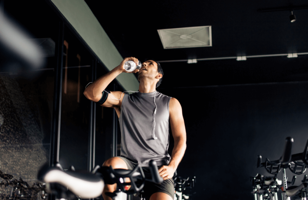 A man drinking water during his workout to avoid pre-workout side effects