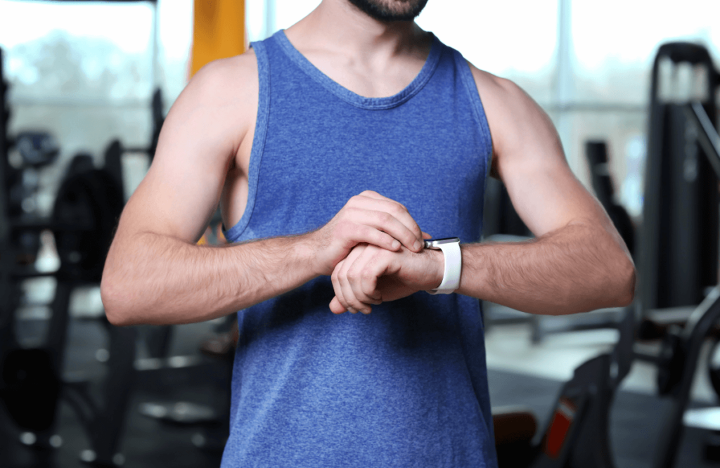 A man at the gym tracking his calories ratio to have the perfect four-pack abs