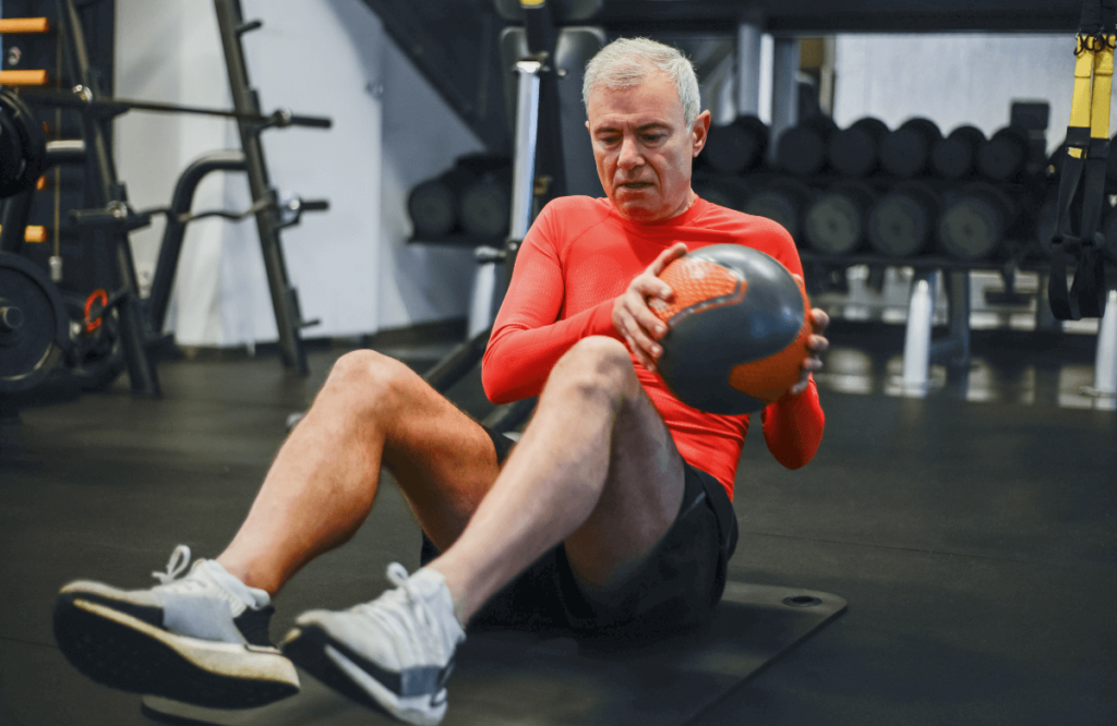 A man training to build muscle after 50 using a ball