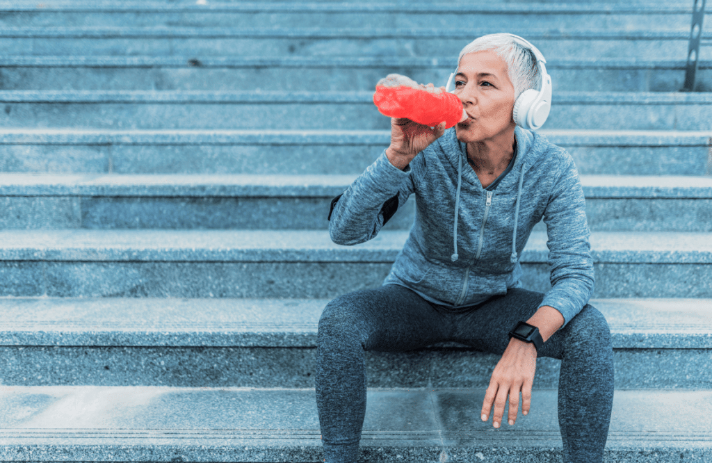 A woman drinking a drink with supplements while building muscles after 50