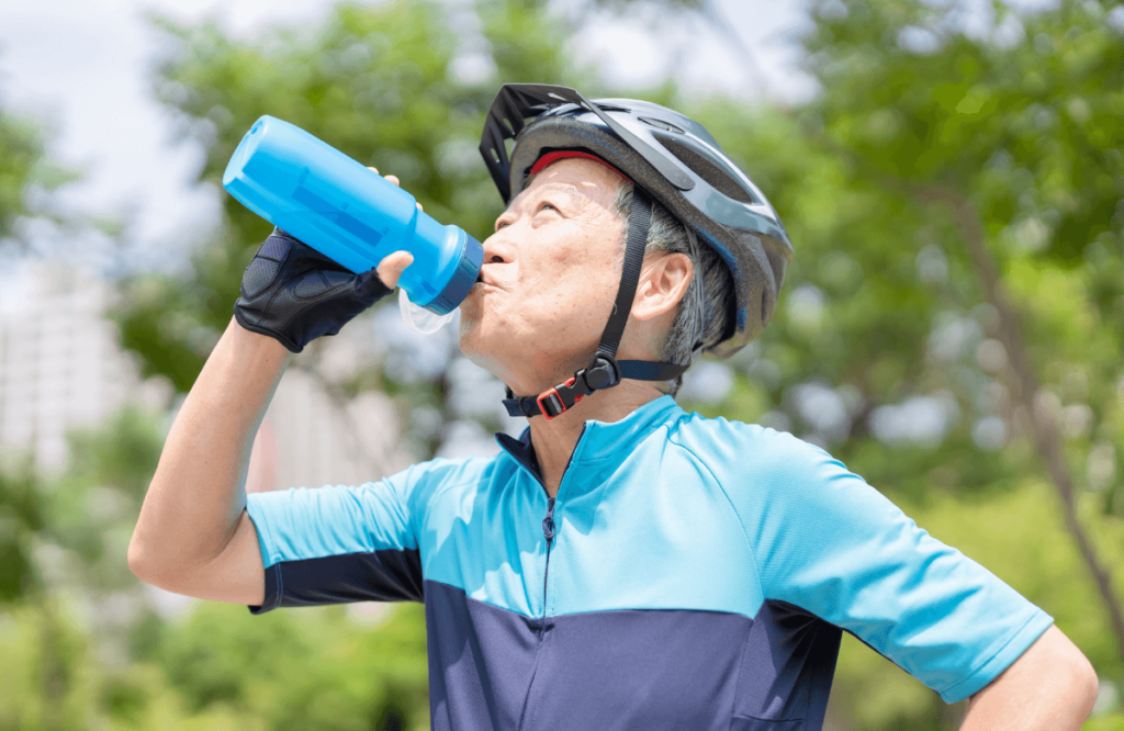 A man building muscle after 50 drinking water on his bike