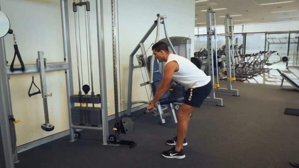 A man performing cable deadlifts at the gym