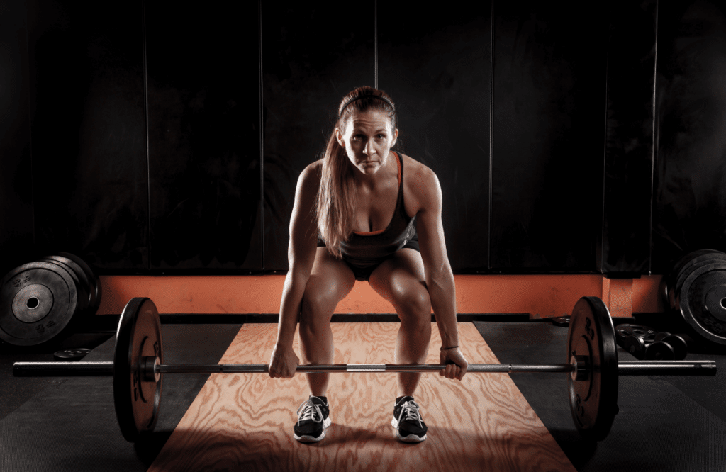 A woman doing banded deadlifts at the gym