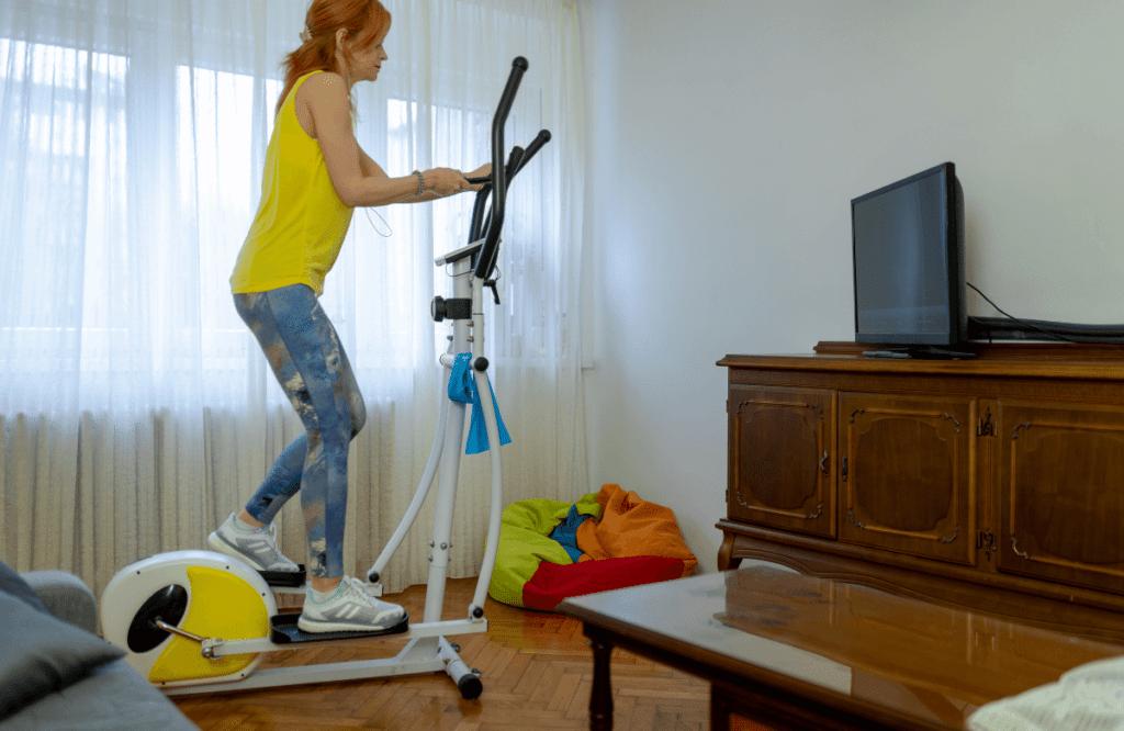 A woman in her apartment using the best elliptical for apartment