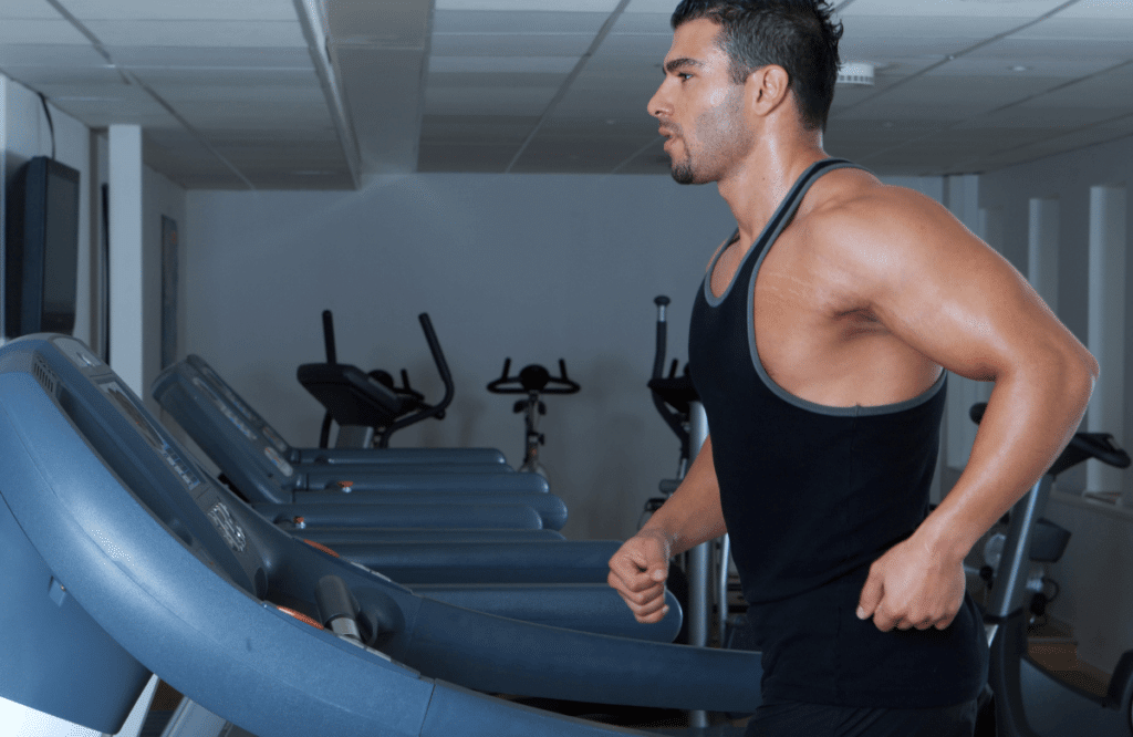 A muscular man running on a treadmill to lose weight