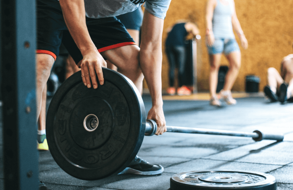 A man preparing his barbell to do landmine rows at the gym