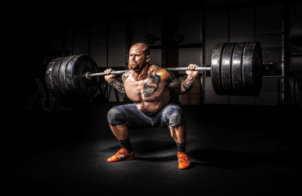 A strong man squatting at the gym to show squats before and after results