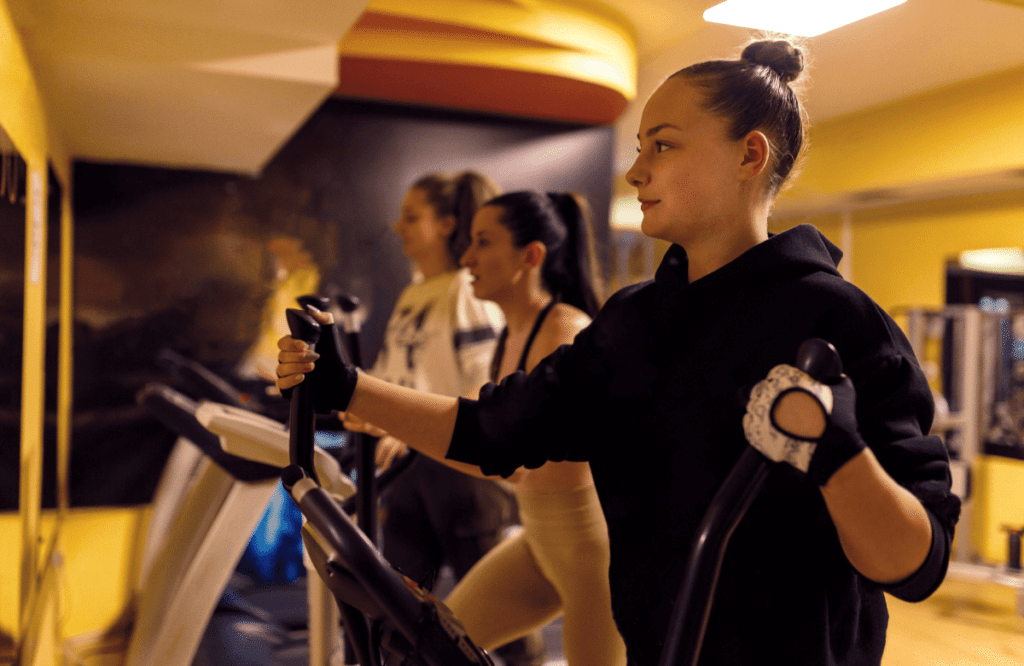 Women at the gym using ellipticals in their price range