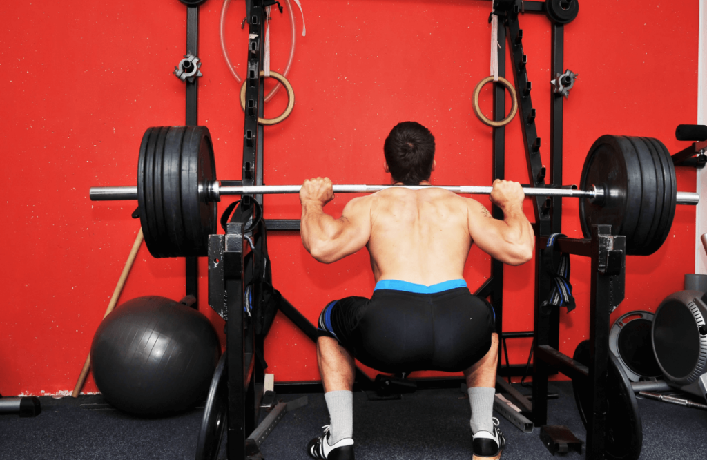 A man at the gym doing squats to show squats before and after results