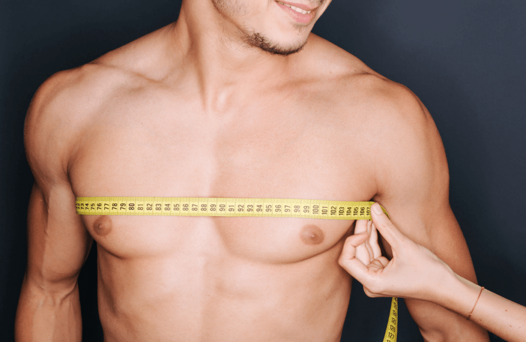 A man measuring if he has the average chest size for men with a tape