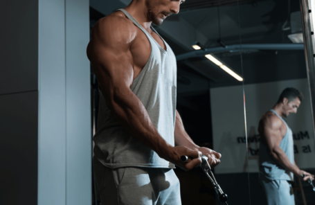 A muscular man doing a brachialis workout at the gym