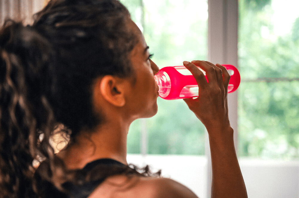A woman drinking water with salt before workout to replenish electrolytes